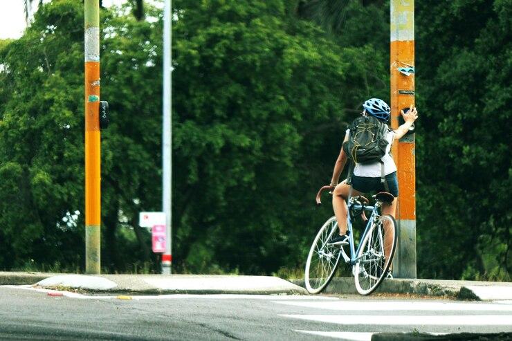 Une femme à vélo qui se repose contre un poteau